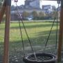 Single Swing (BNS 90cm) playground equipment with a circular netted seat suspended by chains on a wooden frame.