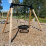 Single Swing (BNS 90cm) with wooden frame and circular black netted seat for playground use.
