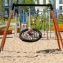 Single Swing (BNS 90cm) with wooden frame and black netted seat on a sandy playground