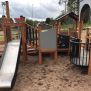 Campanille playground castle with wooden structure, slide, and climbing elements on sandy ground.